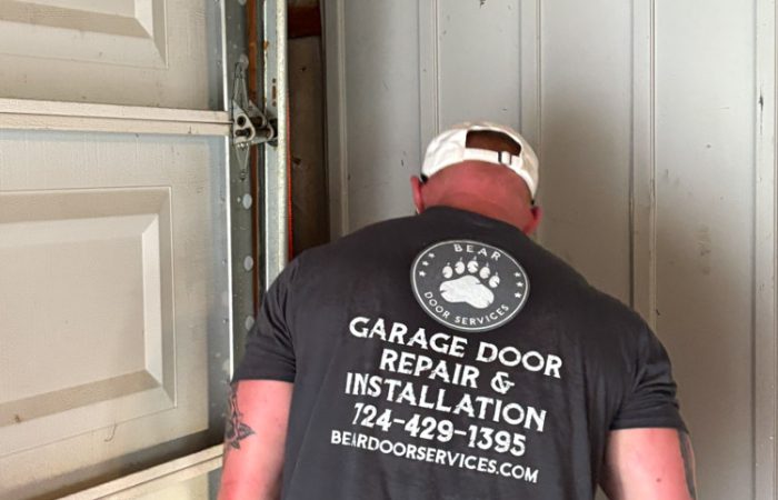 Bear Door Services technician inspecting garage door hardware