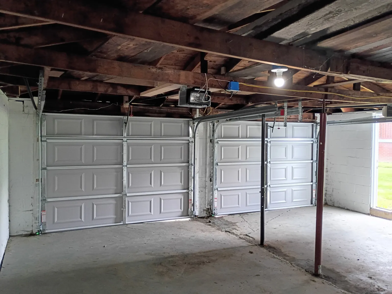 Two clean new white garage doors by Bear Door Services
