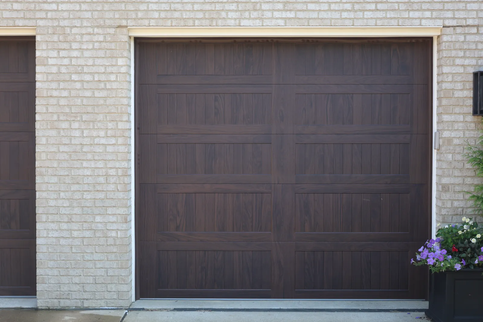 A modern woodgrain garage door installed by Bear Door Services