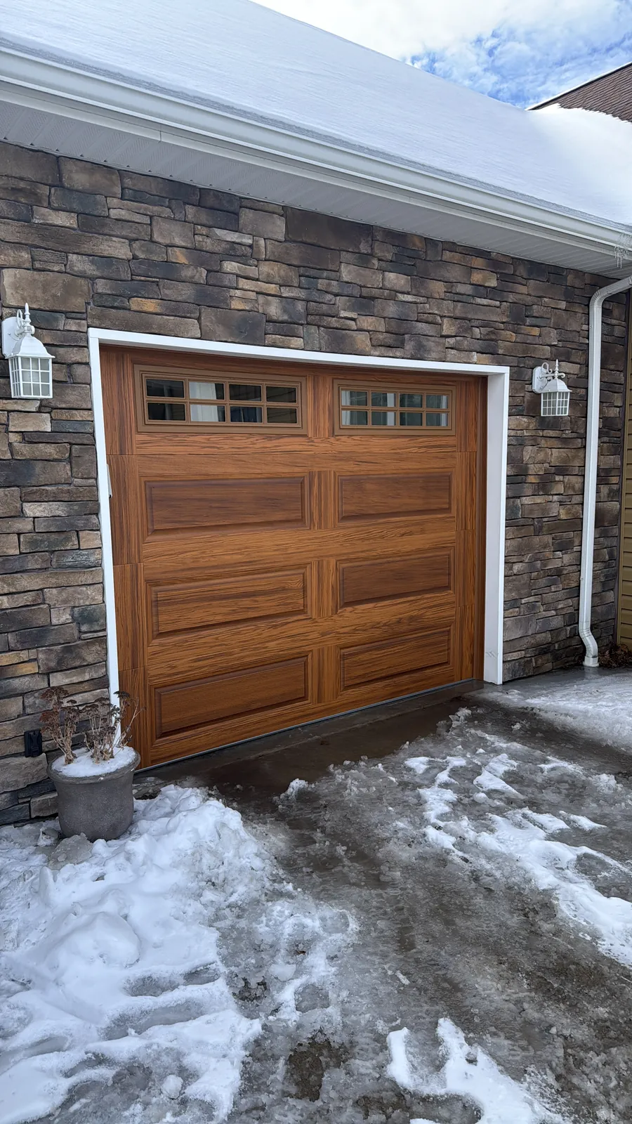 Premium Insulated Woodgrain garage after — A full winter curb-appeal refresh with premium insulated woodgrain doors.