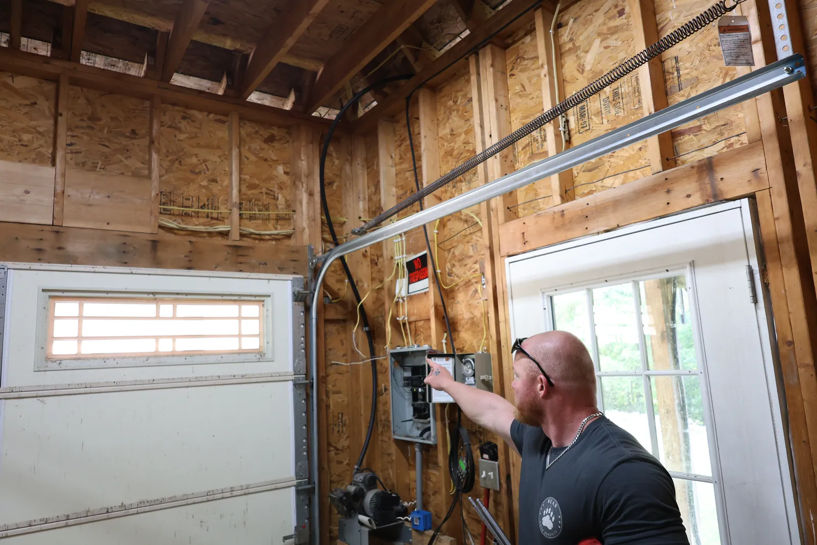 Full-View Aluminum & Glass garage before — An aged paneled door reborn as a modern full-view aluminum & glass door.